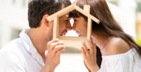 Man and women holding a wood house outline