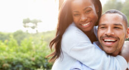 Woman embracing a man from behind outside