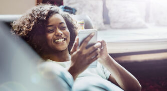 Woman using her phone while sitting on a sofa