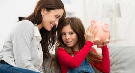 Mom watching her daughter shake her piggy bank