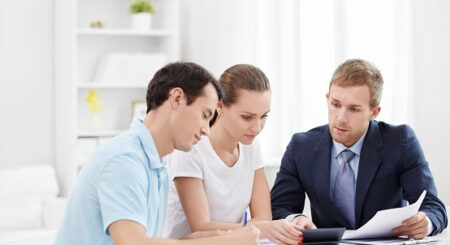 Young Couple Signing Contract while banker helps them