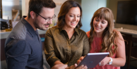 Three people looking at a tablet