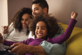 Family smiling while sitting on a couch