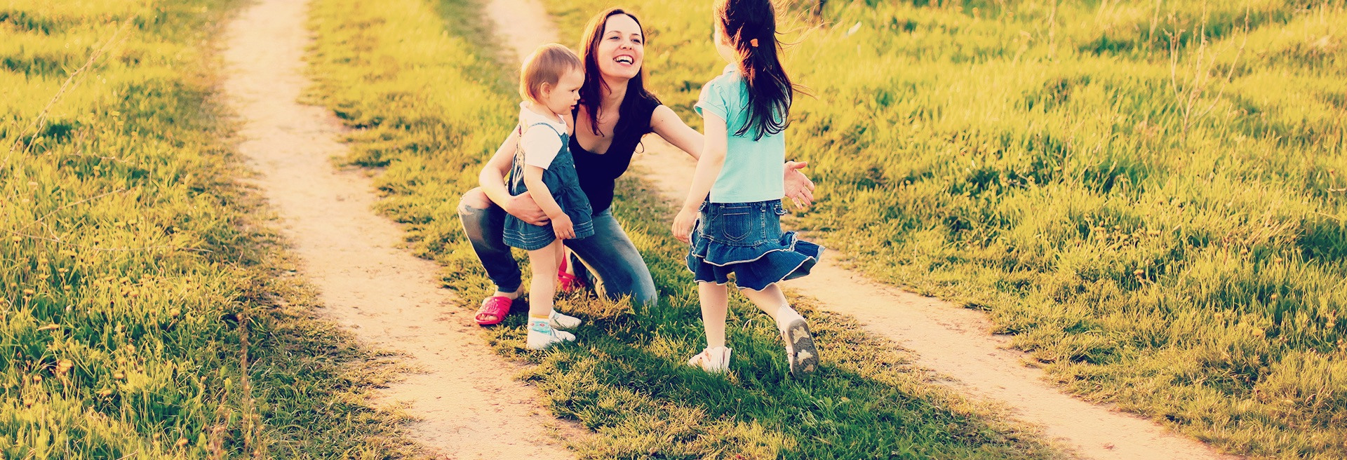 Mom hugging her two girls on a gravel road